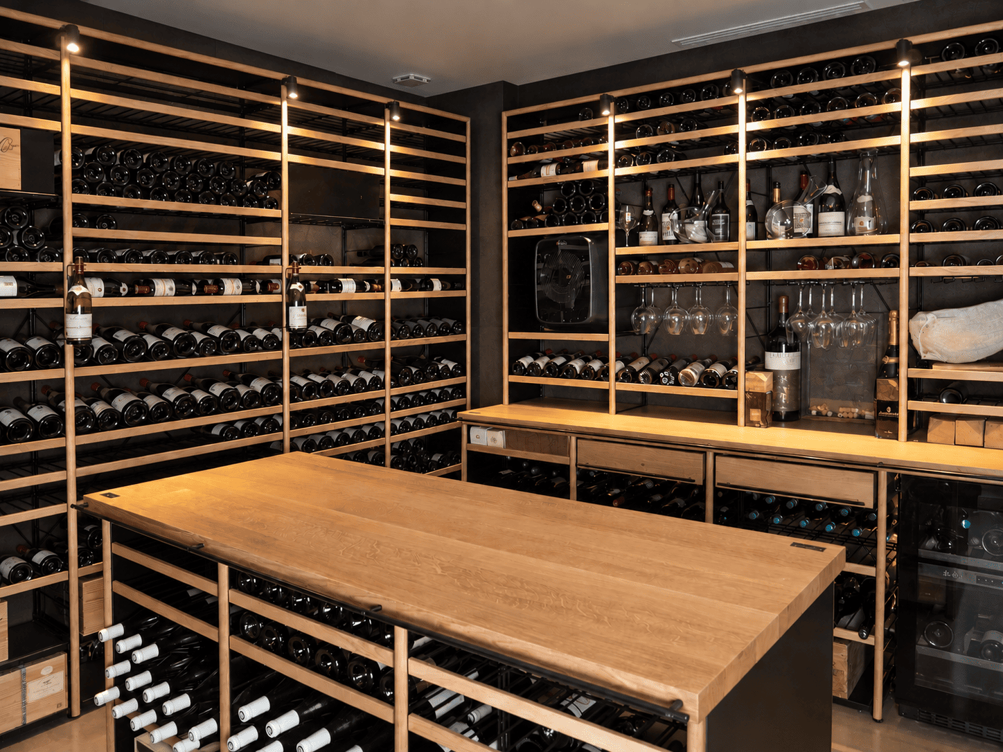 Cave à vin aménagée avec mobilier en bois et métal Architecture Intérieure du Vin